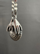 Load image into Gallery viewer, Hands holding a moissanite set in 22k gold