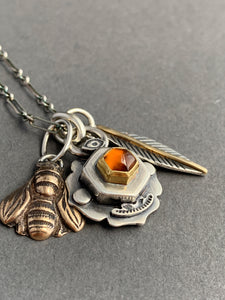 Honey comb charm necklace, Hessonite garnet set in 22k gold, with a bronze bee, and feather with an 18k gold accent