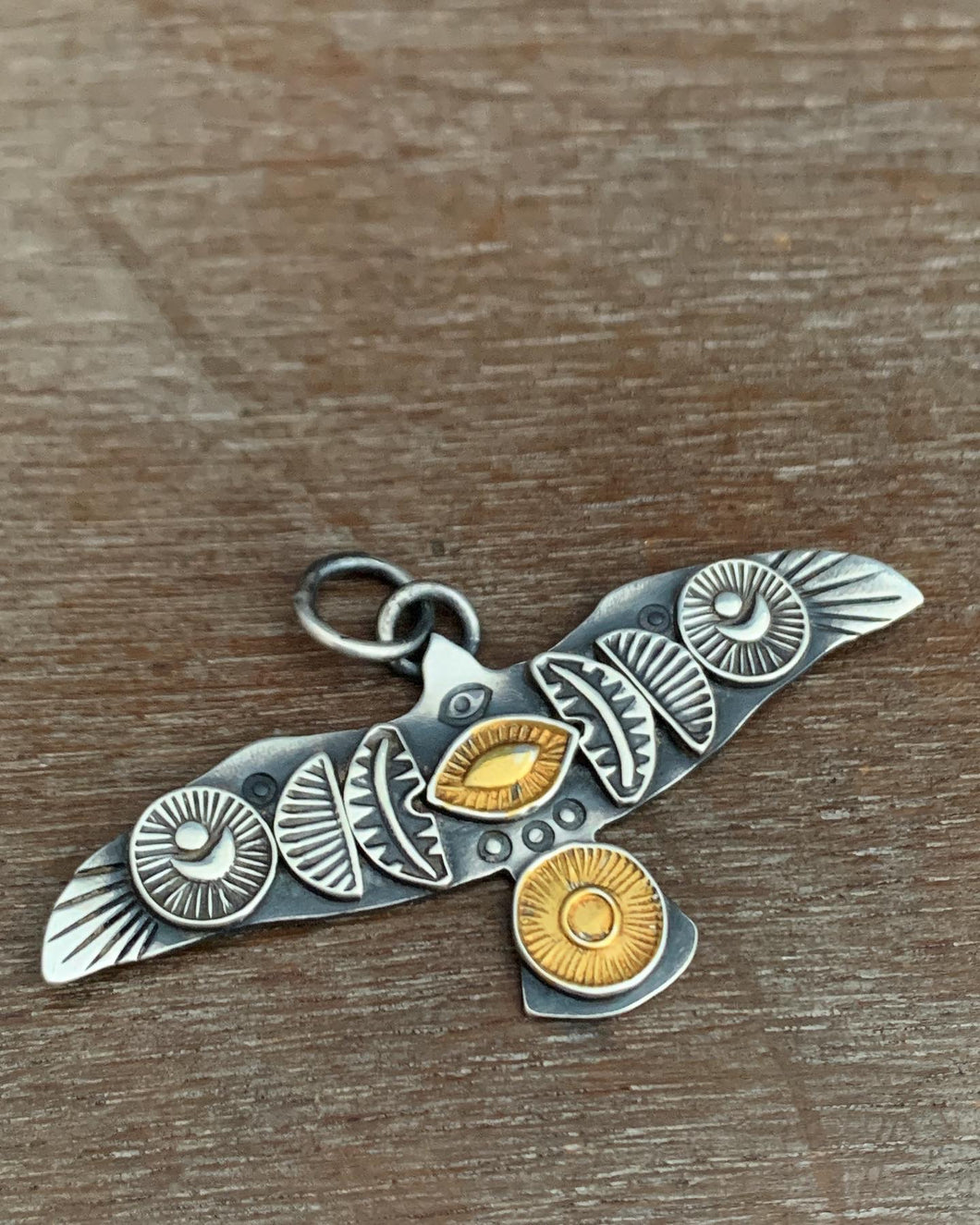 Large golden sun and eye stamped bird pendant