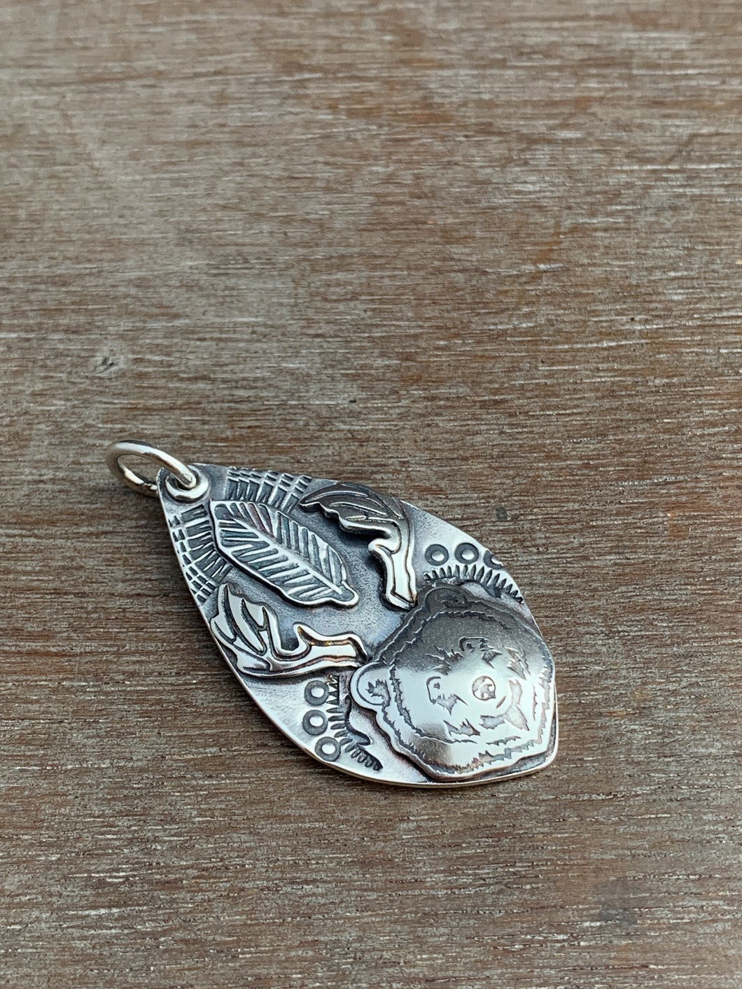 Sterling silver bear with antlers and a feather pendant